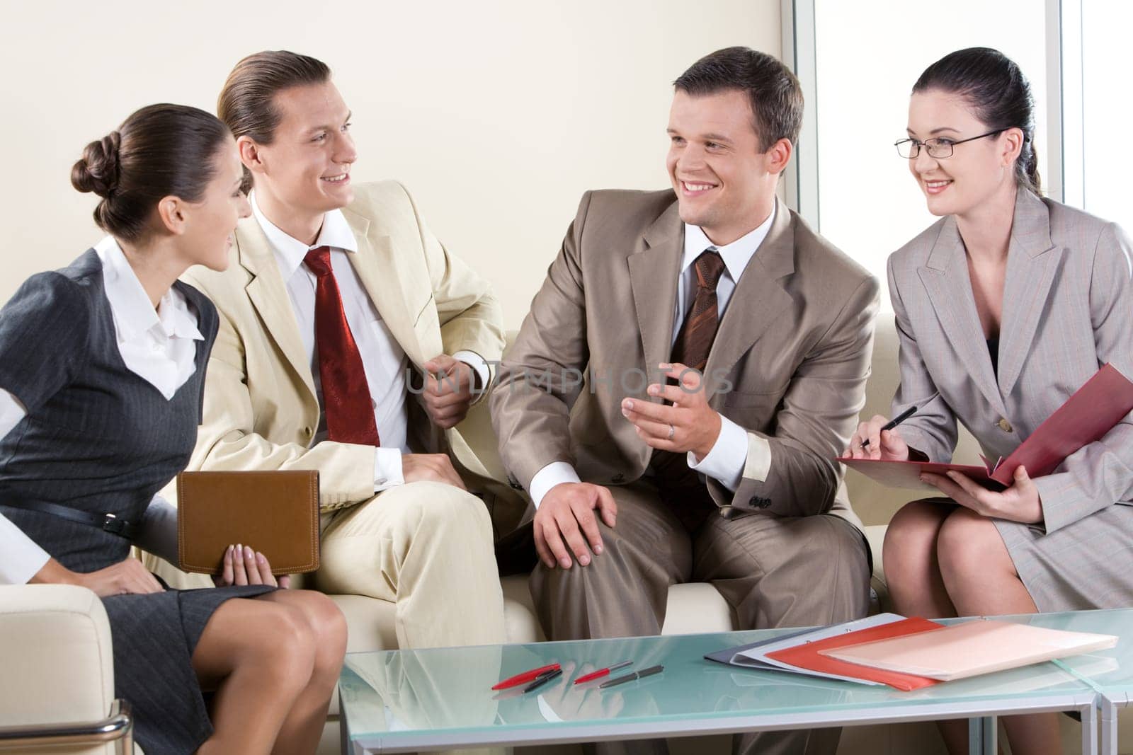 Portrait of business partners sitting on sofa and negotiating