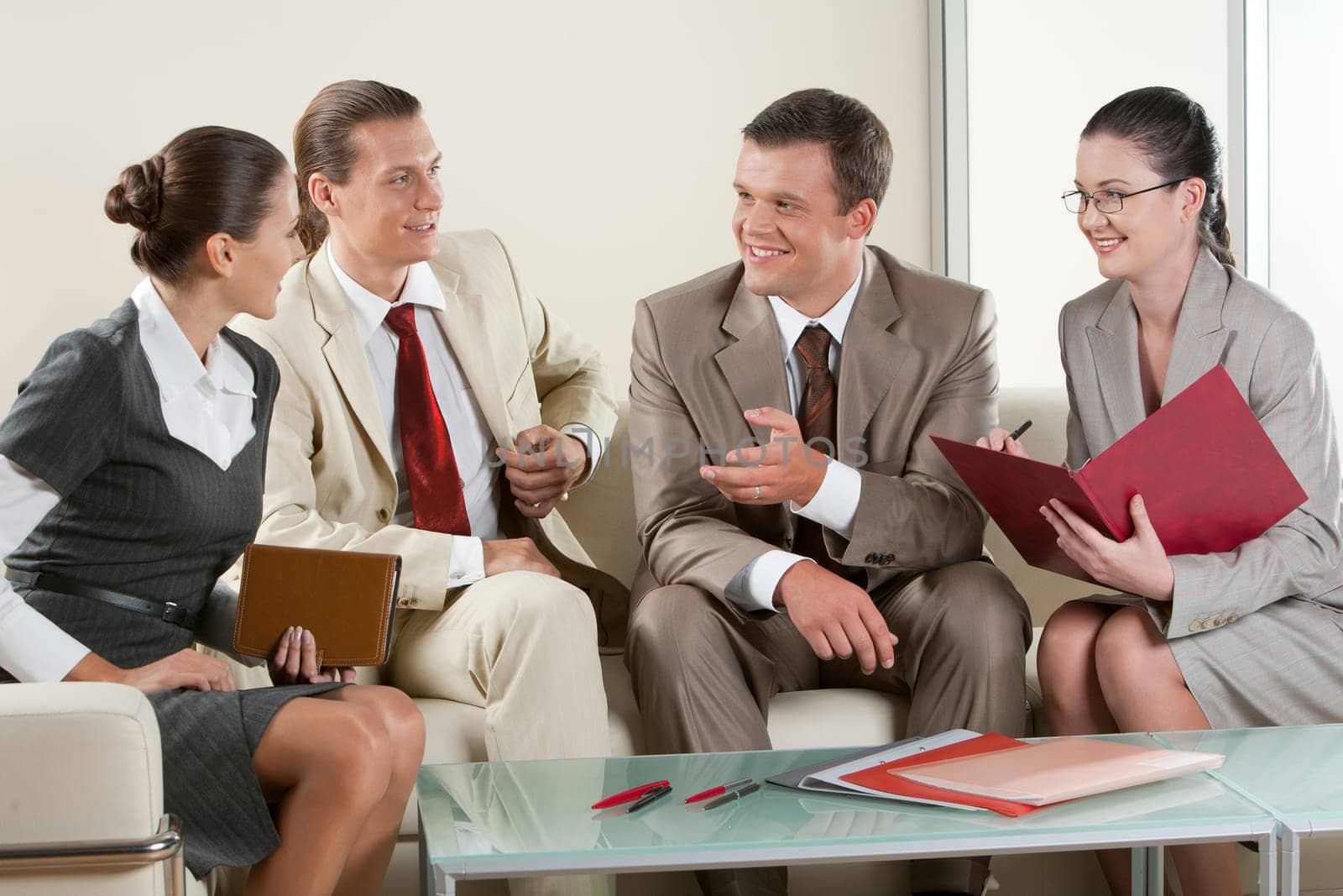 Portrait of business people sitting next to each other and communicating at business meeting