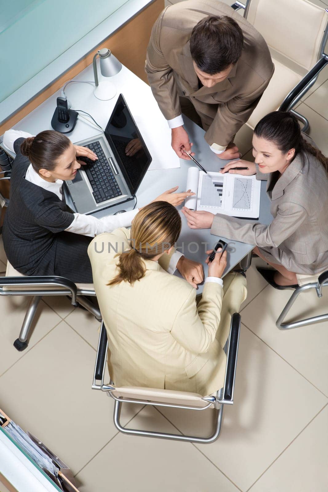 View from above of successful business partners sitting at table and interacting