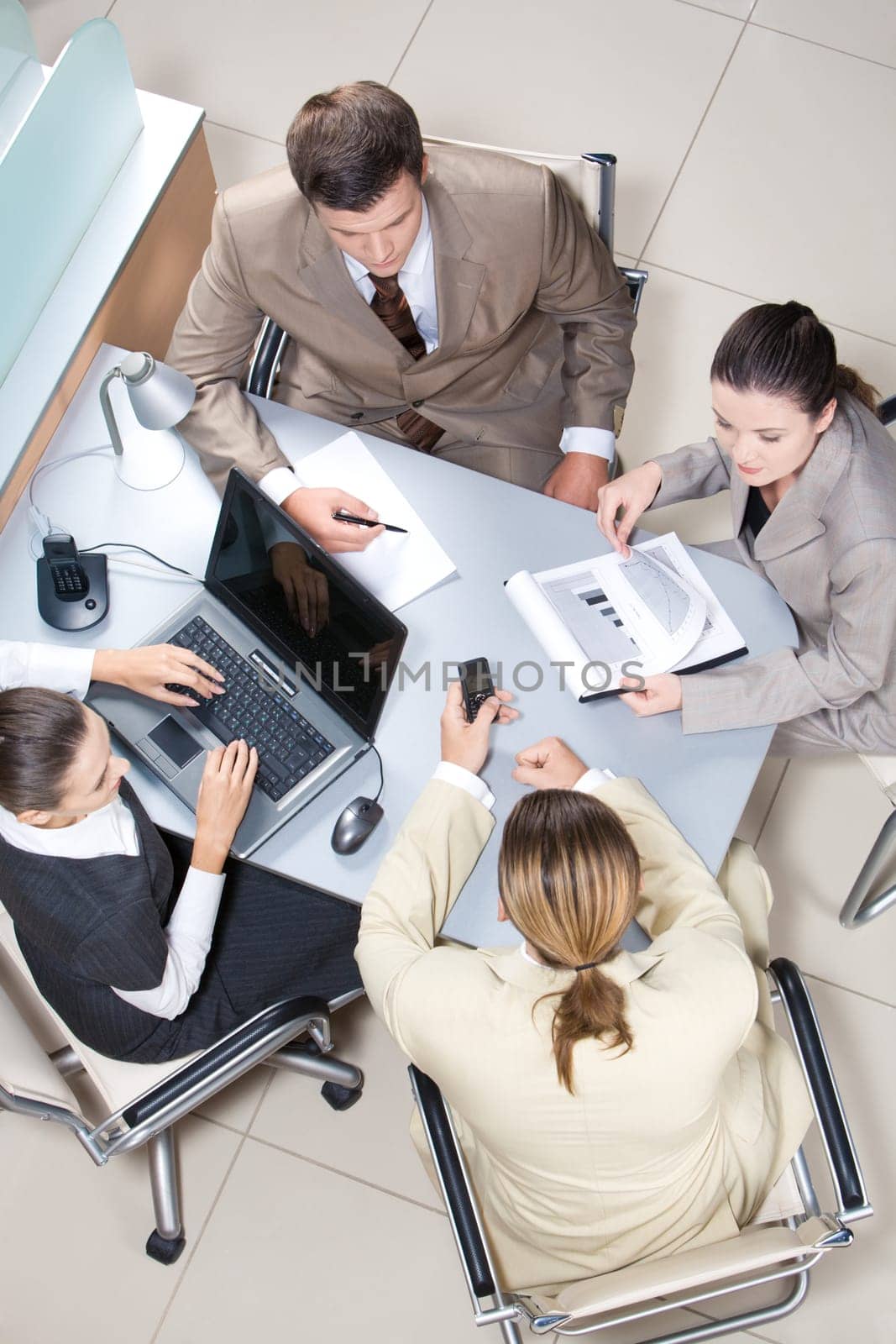 Above view of working business group sitting at table during corporate meeting