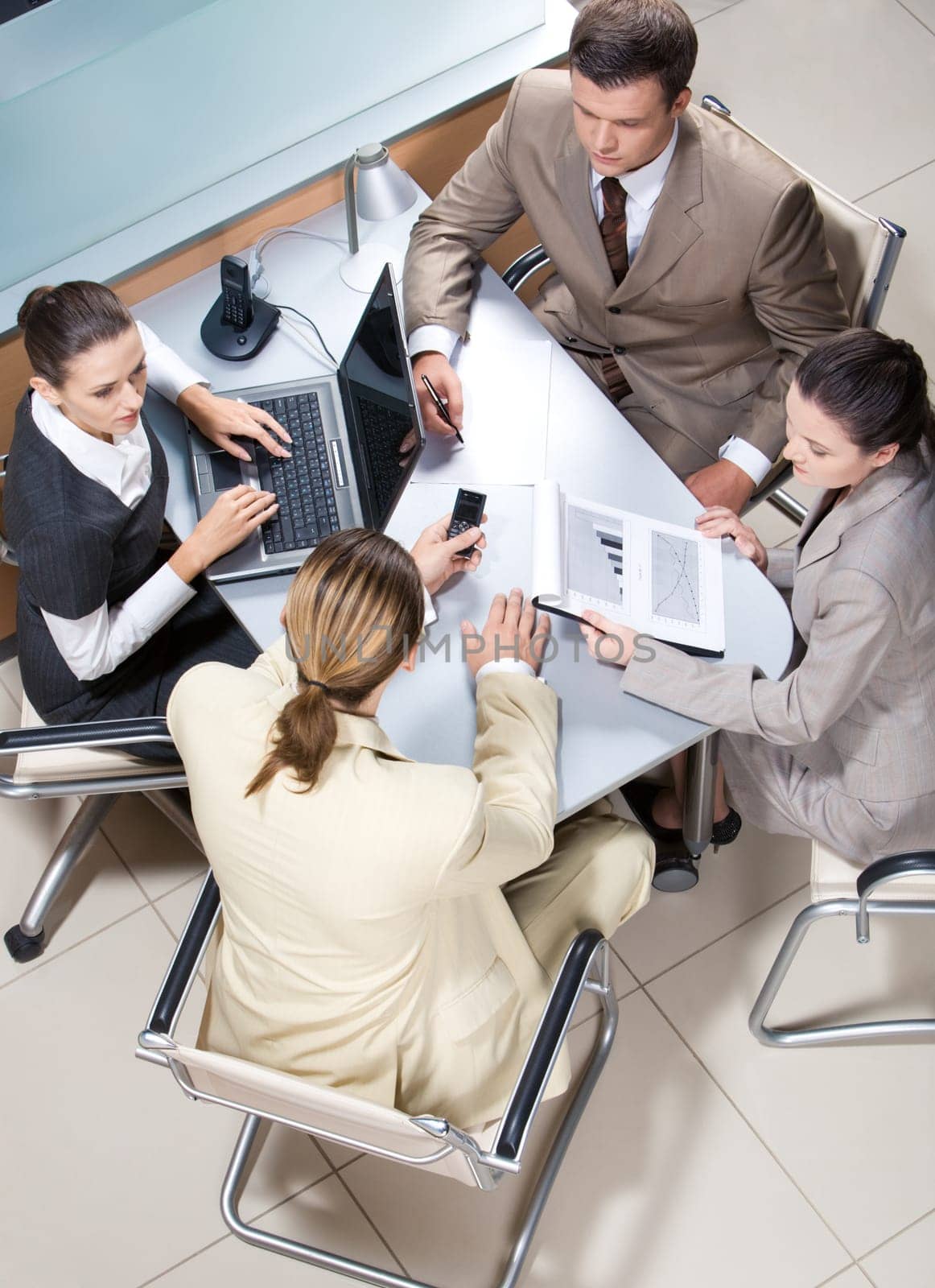 View from above of serious business group working at table in office