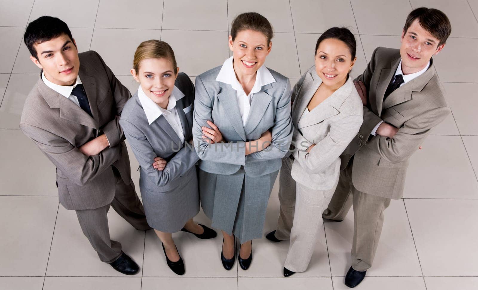 Portrait of confident business group standing on the floor and looking at camera with smiles