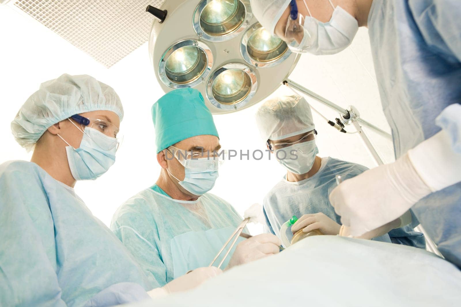 Image of surgeons and nurses near patient lying on operating table