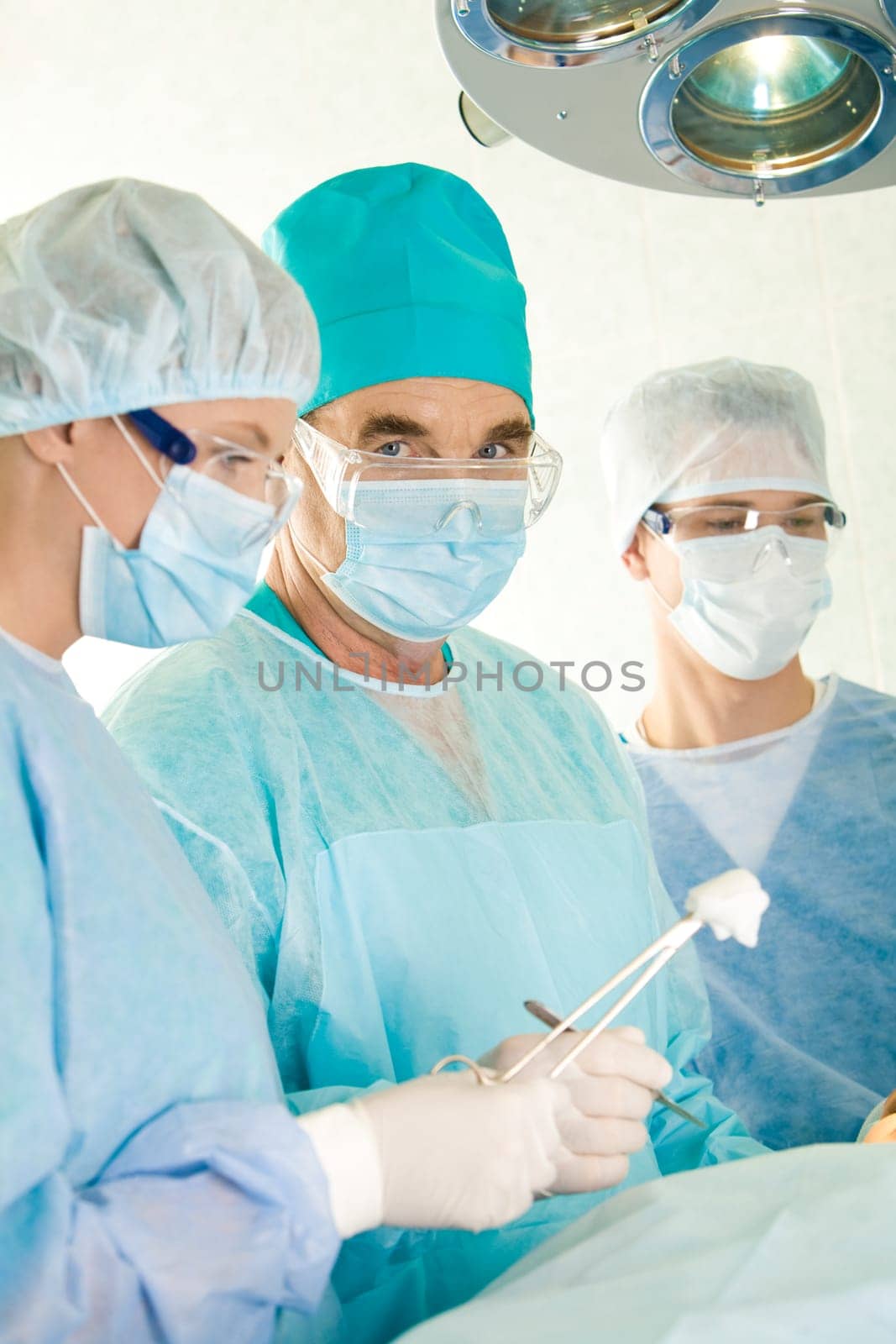 Image of elderly surgeon looking at camera during operation
