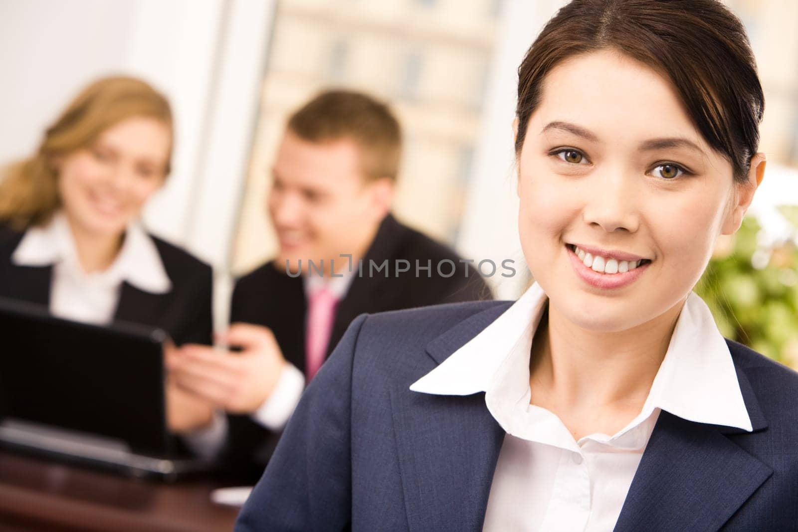 Photo of happy white collar worker looking at camera in working environment