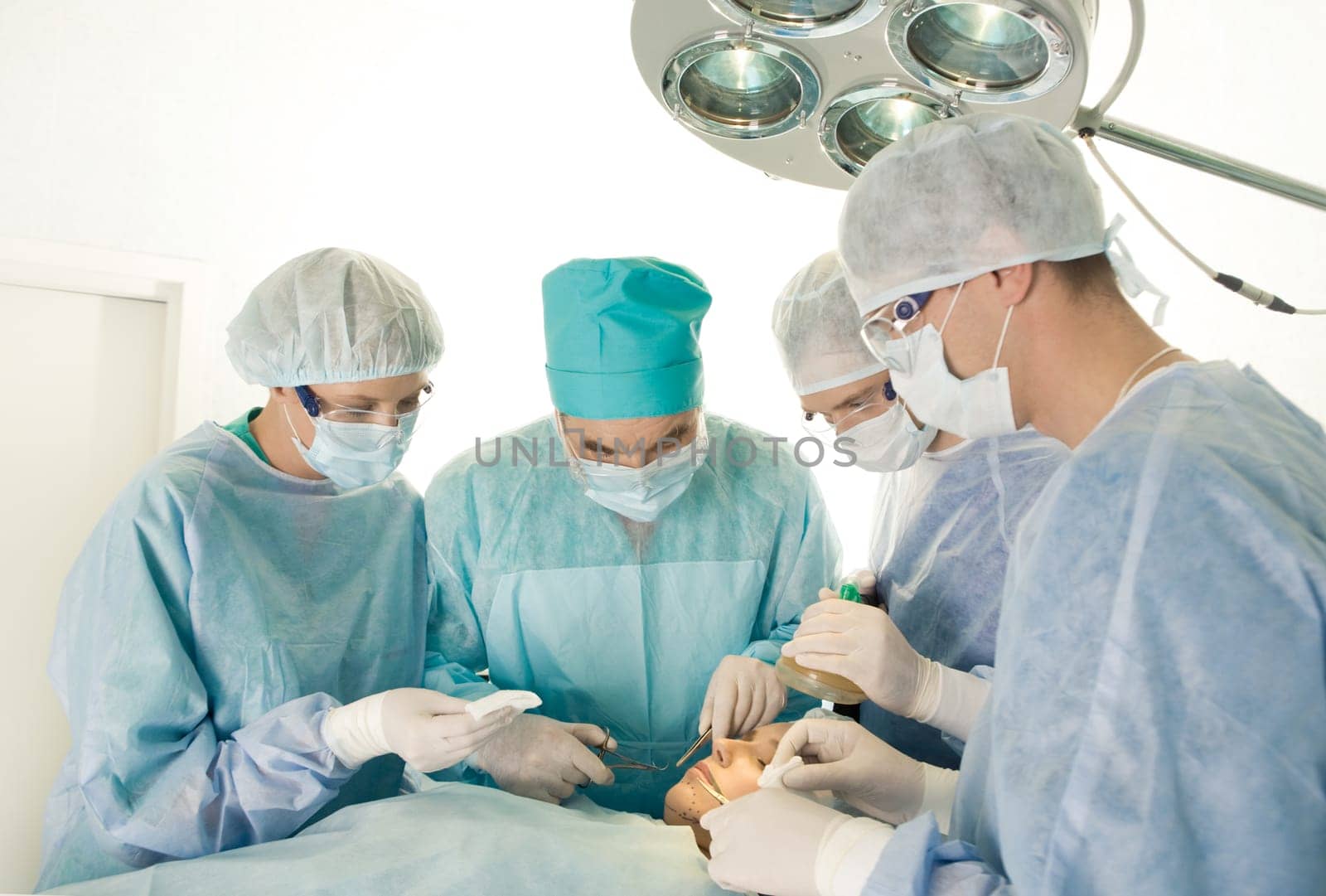 Portrait of four medical professionals performing an operation on  woman