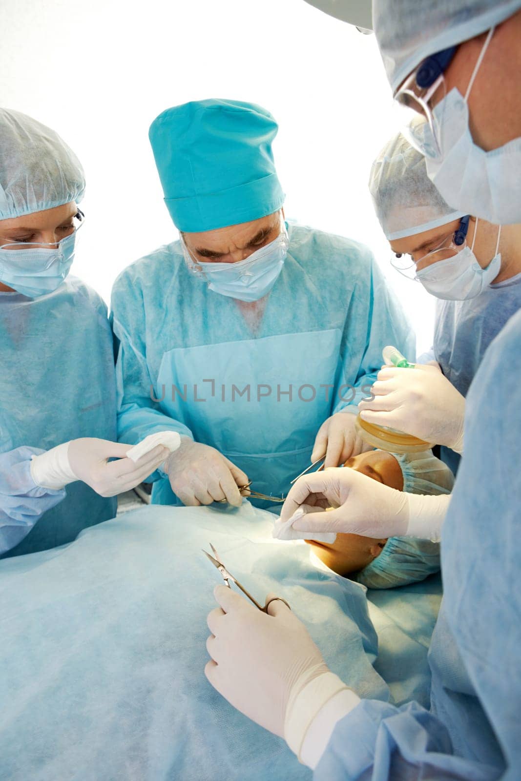 Portrait of four medical professionals performing an operation on woman