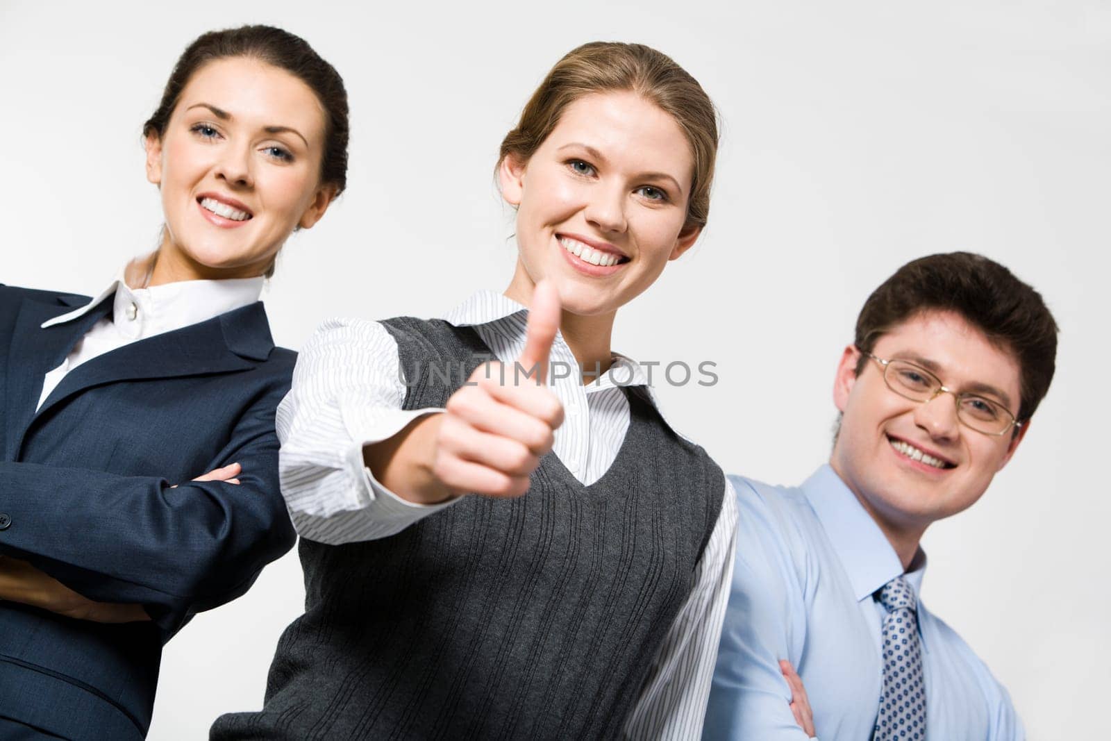 Smiling woman demonstrates thumb up with business people