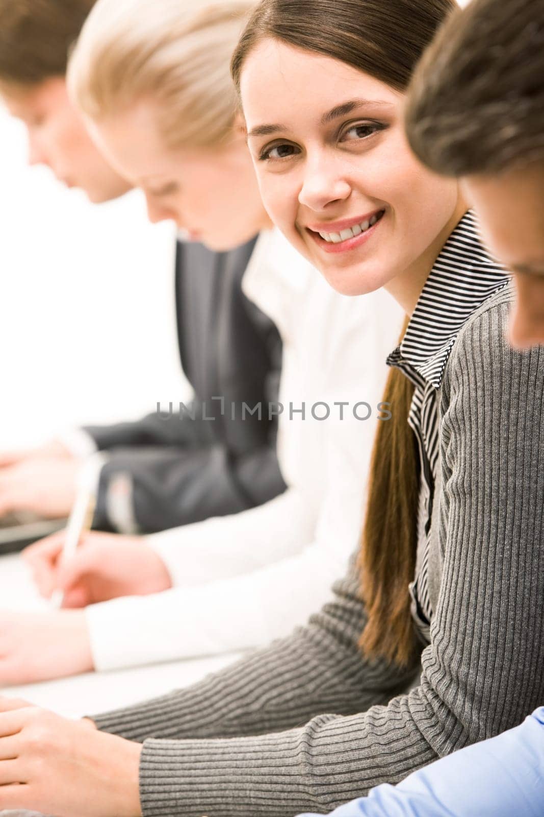 Successful businesswoman looking at camera from between partners