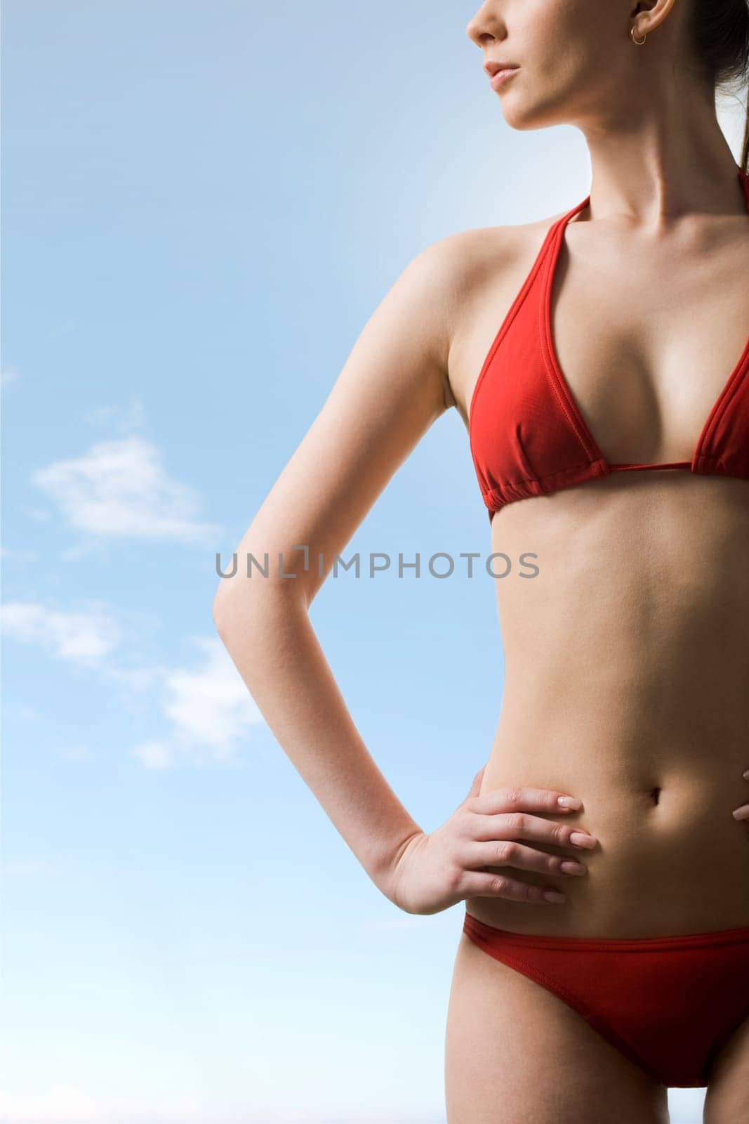 Image of luxurious woman in red bikini posing before camera at summer