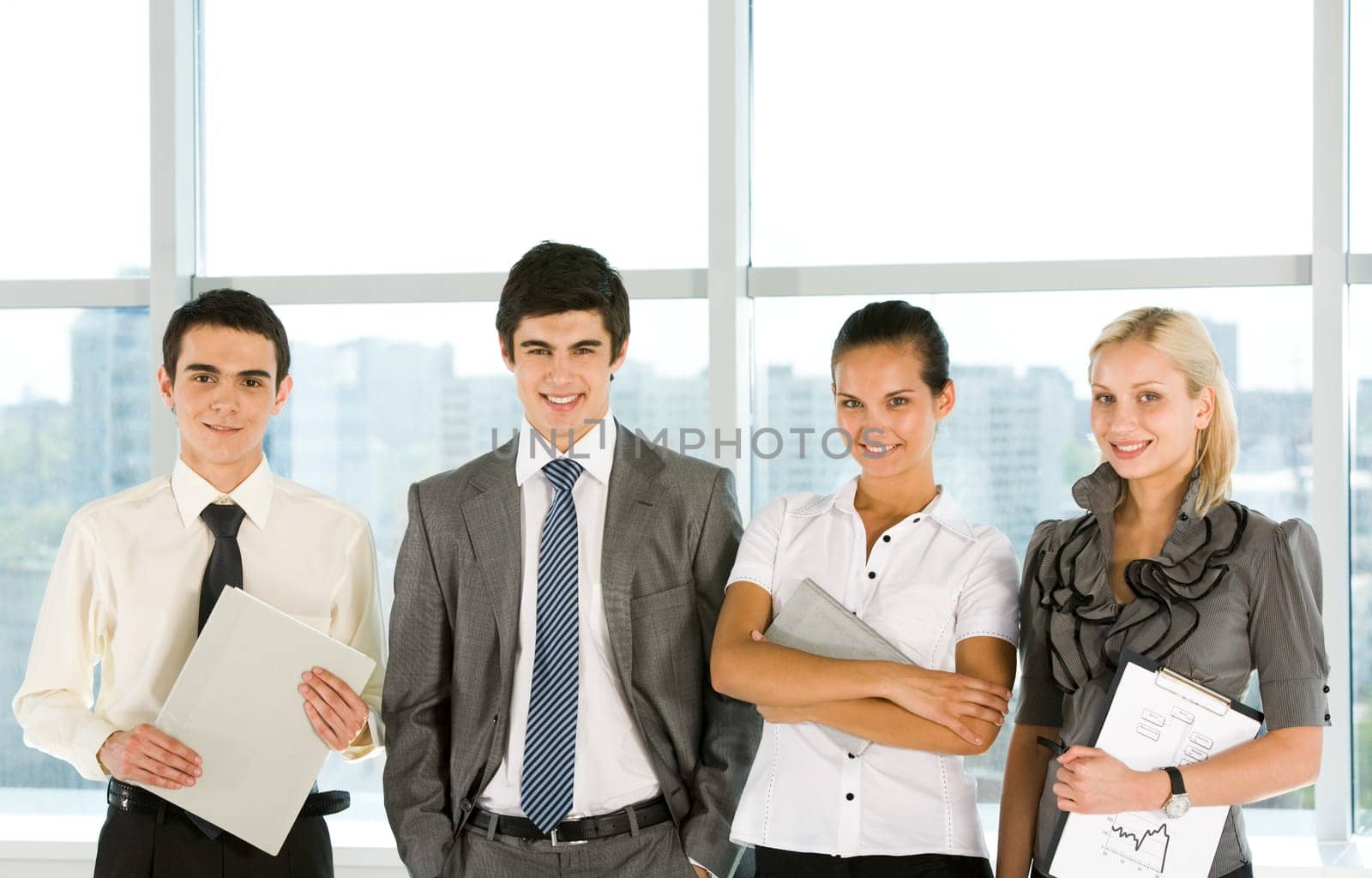 Portrait of smart business group standing in row and looking at camera with smiles