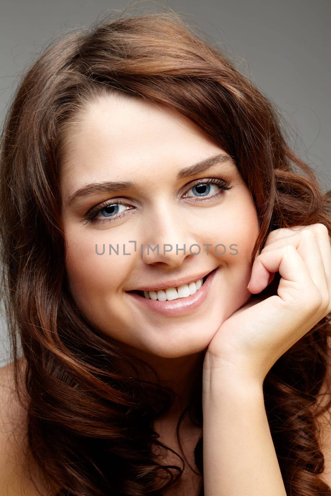 Portrait of charming girl touching her face and looking at camera