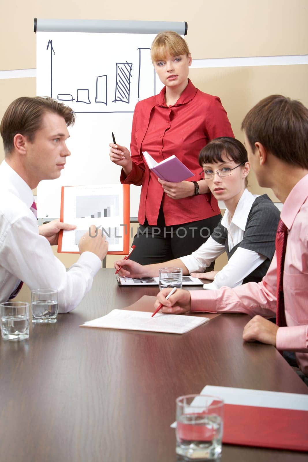 Vertical image of business team talking during meeting while confident man explaining something