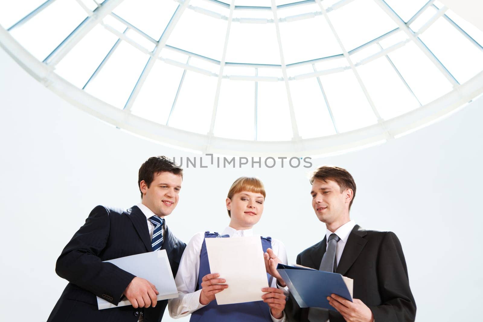 Photo of confident business people looking at paper in female hand at meeting