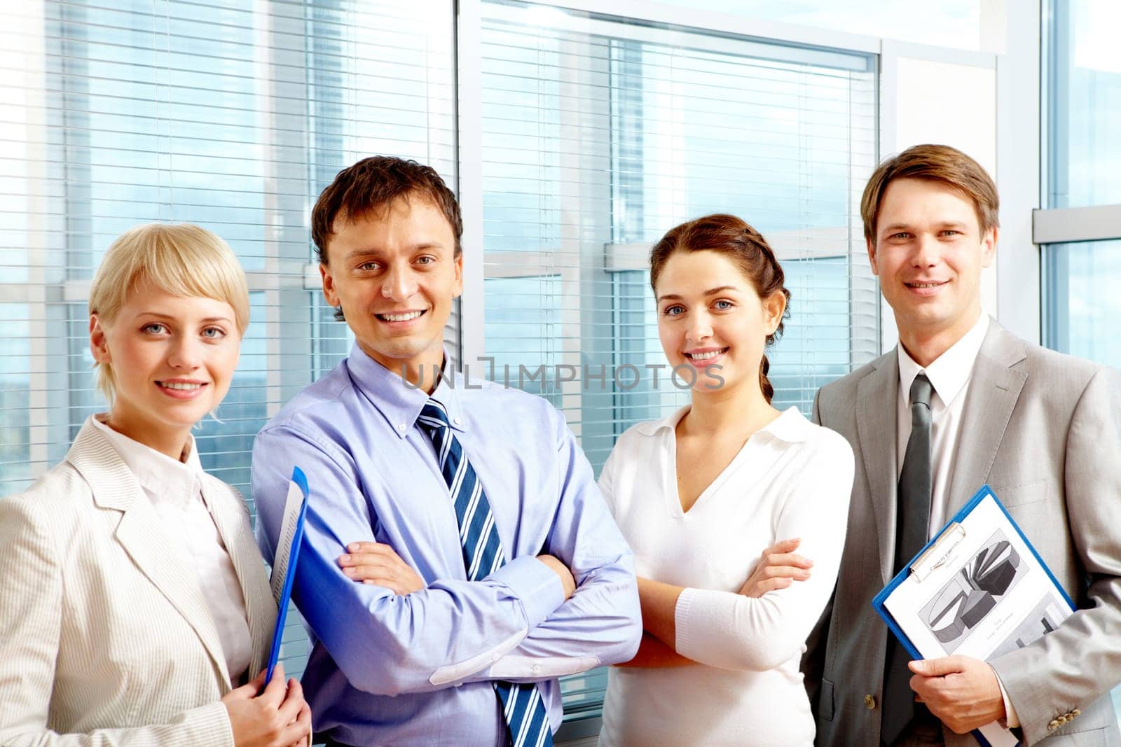 Portrait of smart business people standing next to each other and looking at camera