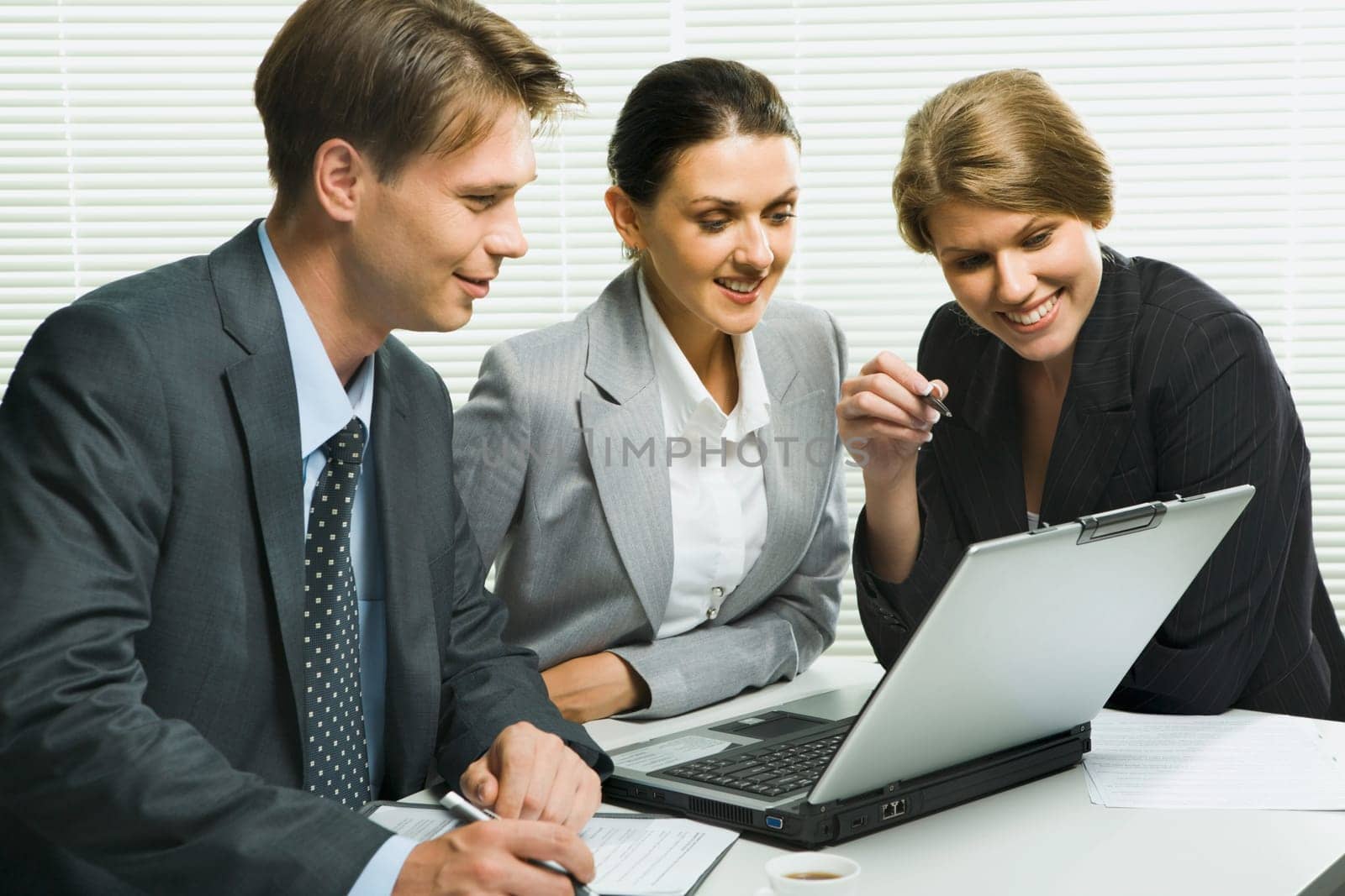 Business woman is explaining the correct way of analysis to her colleagues in  the office