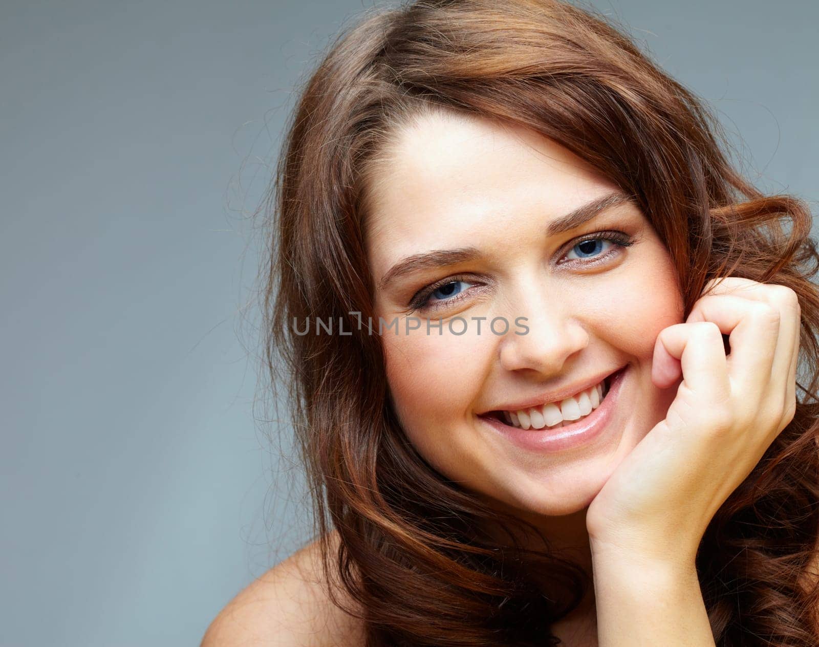 Portrait of happy female touching her face and laughing