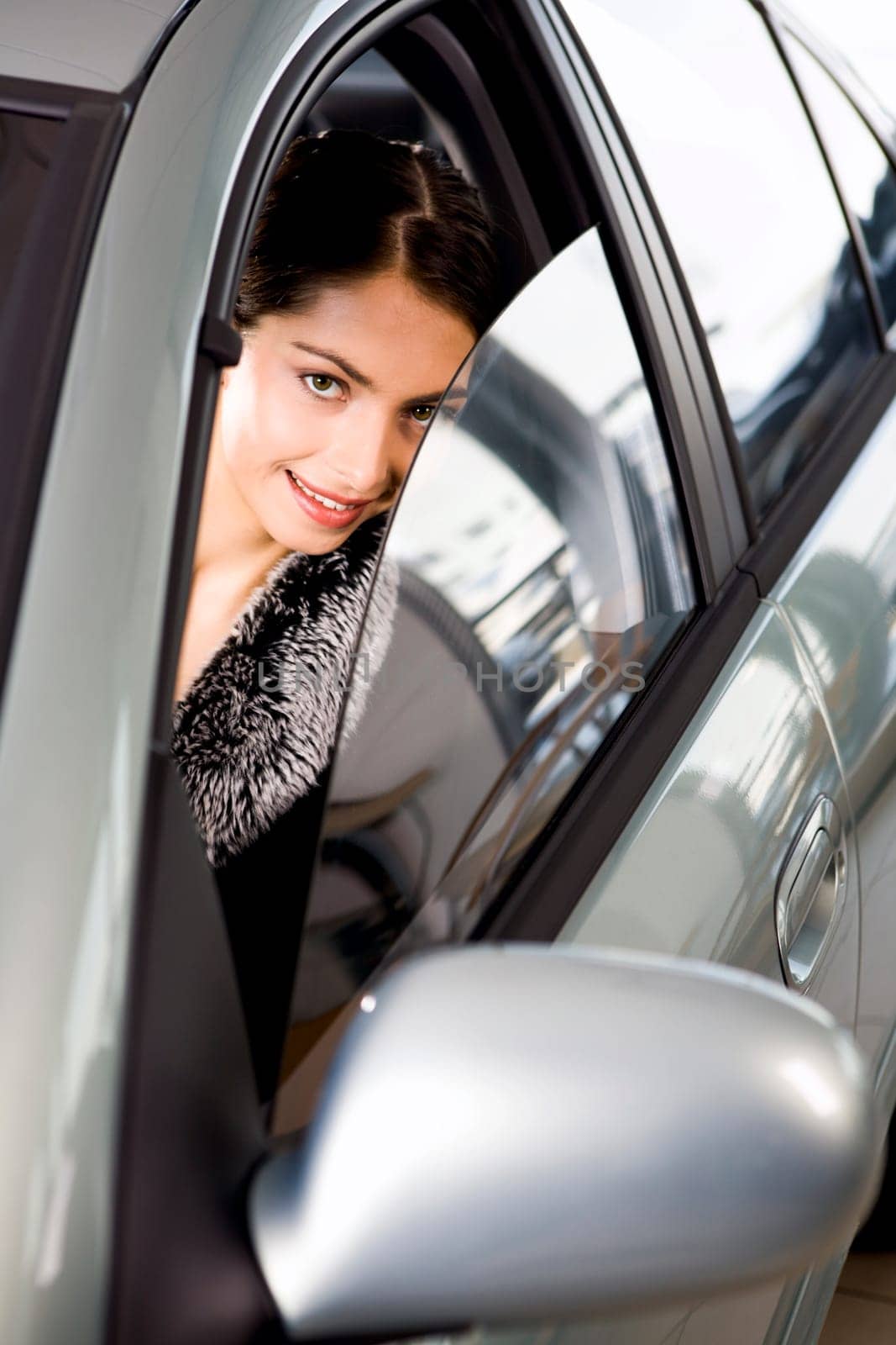 Portrait of vivid brunette looking with interest through the window of her car