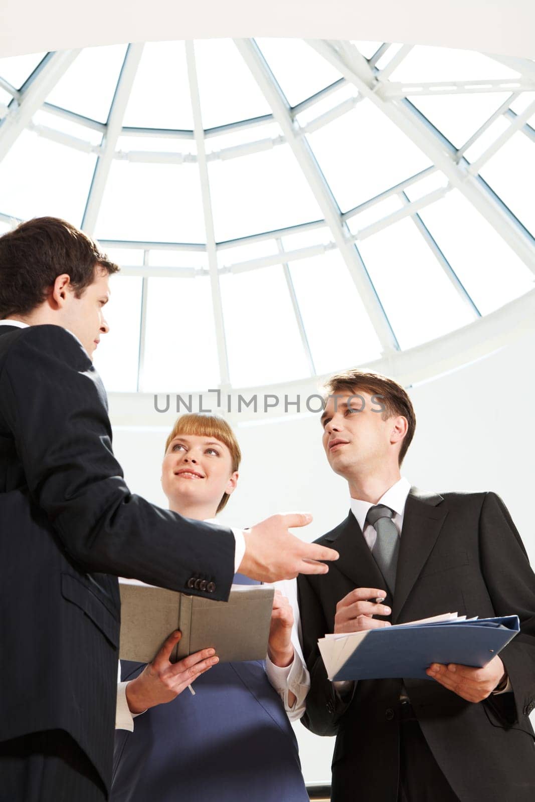 Image of smart professional explaining something to his colleagues at meeting