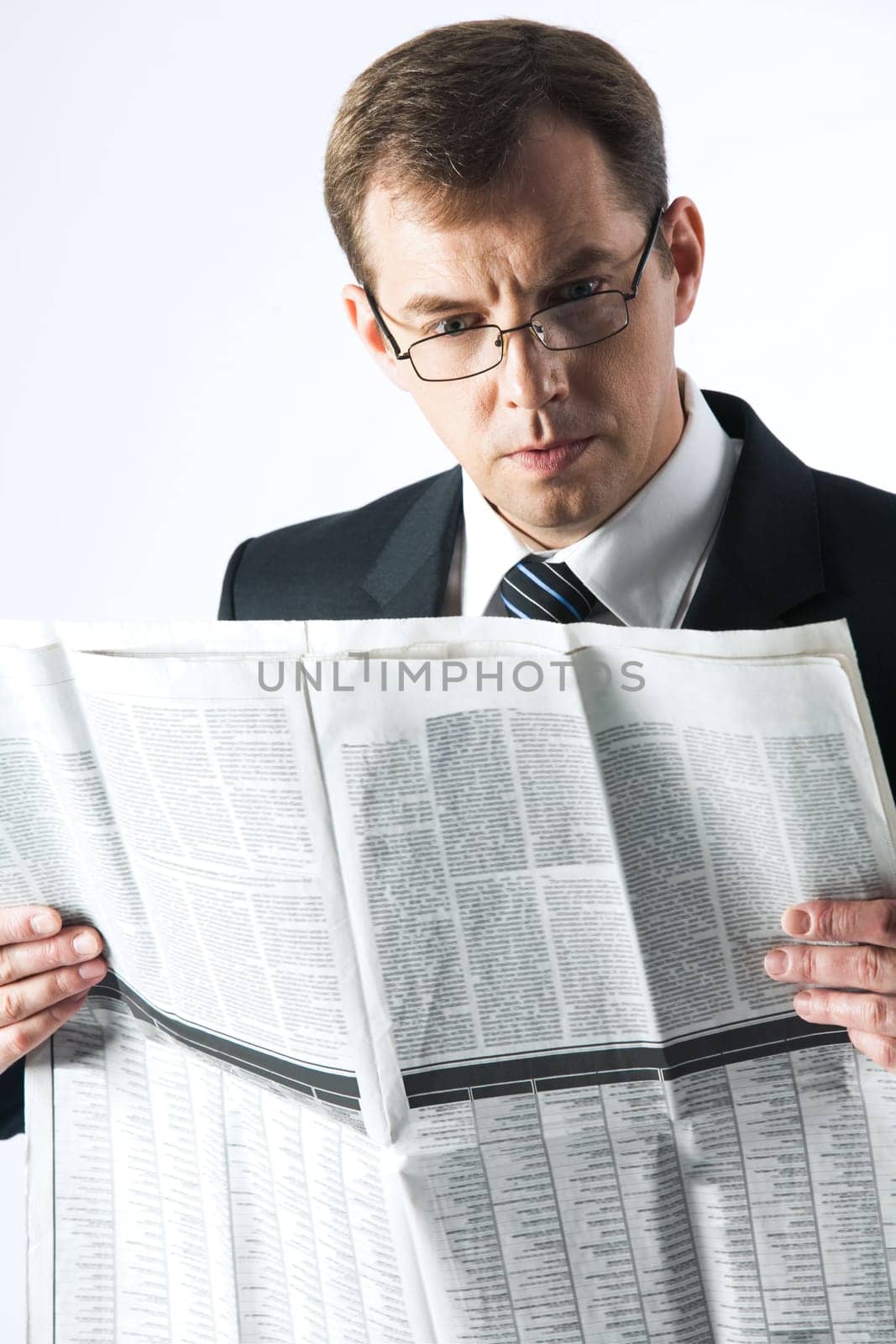 Vertical image of amused businessman reading newspaper