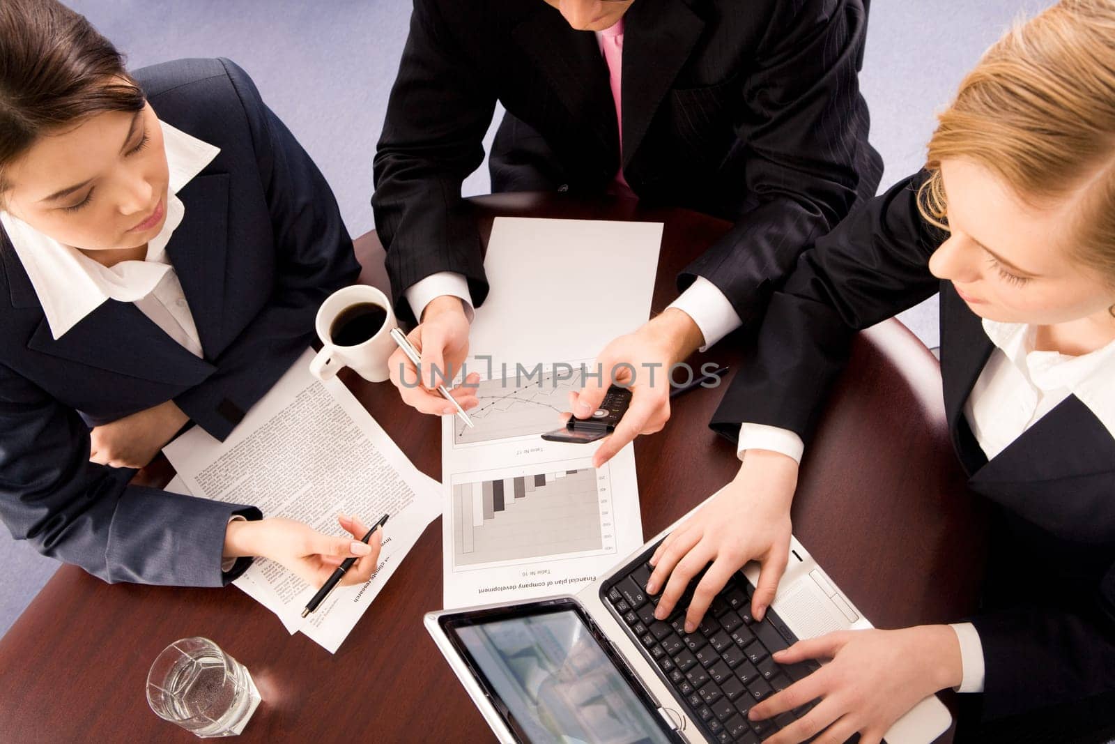 View from above of business group sitting round table and interacting with each other