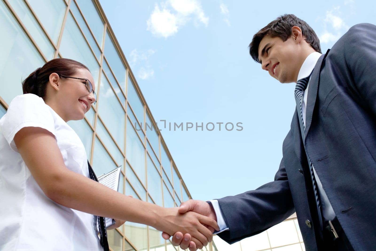 Image of successful partners handshaking after striking deal