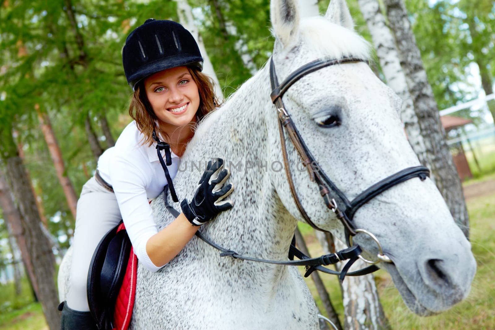Image of happy female jockey on purebred horse outdoors