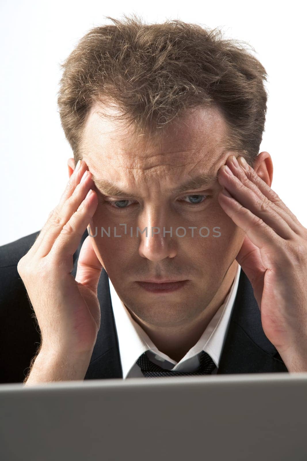 Photo of frustrated businessman touching his head while thinking at work