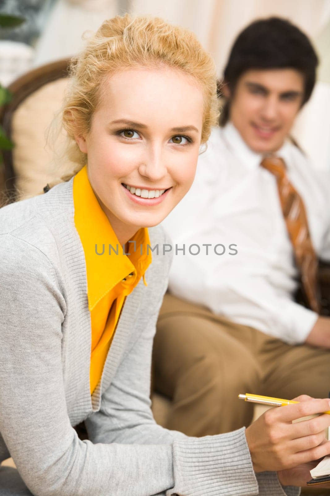 Portrait of beautiful businesswoman looking at camera on the background of man