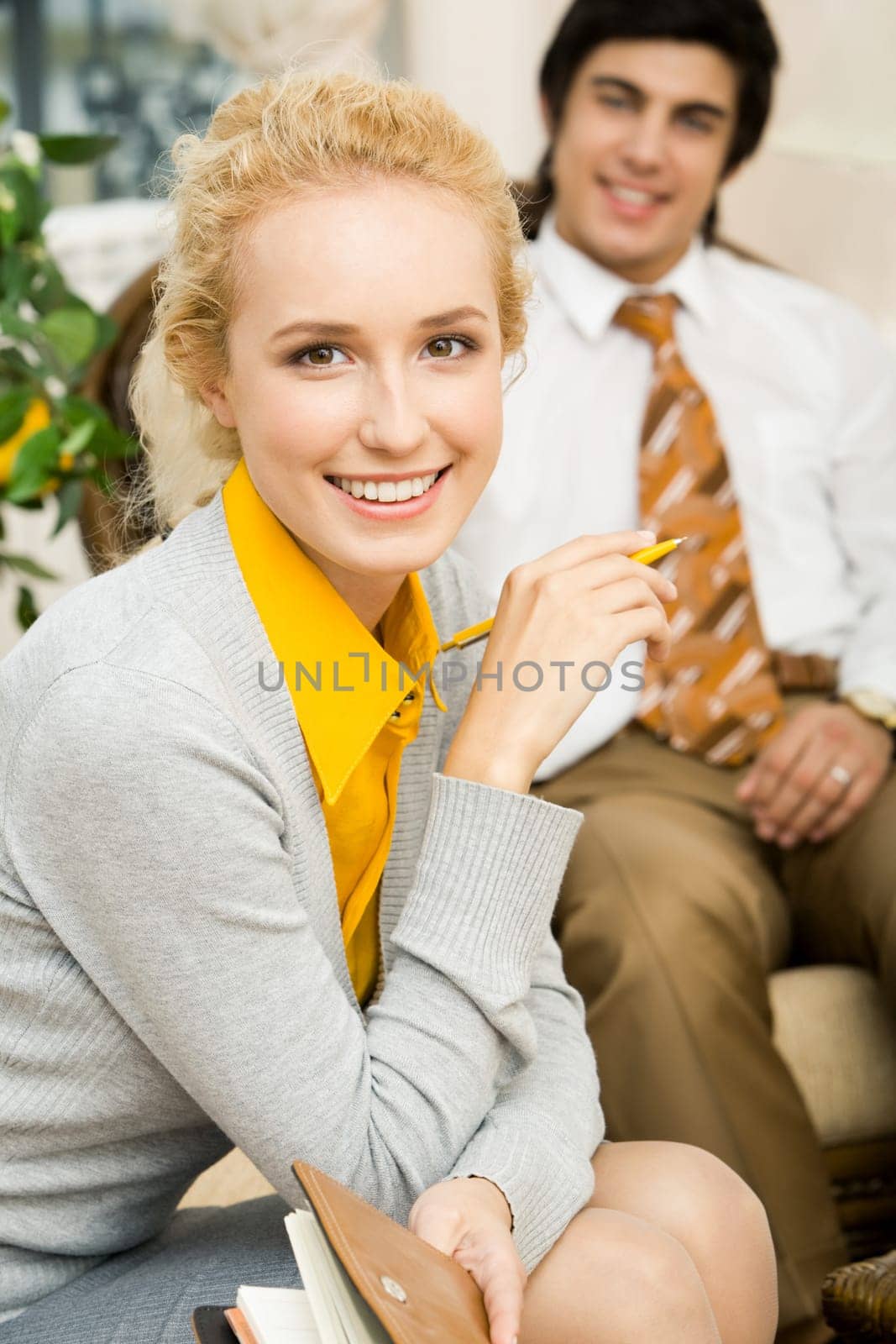 Portrait of beautiful businesswoman looking at camera on the background of men
