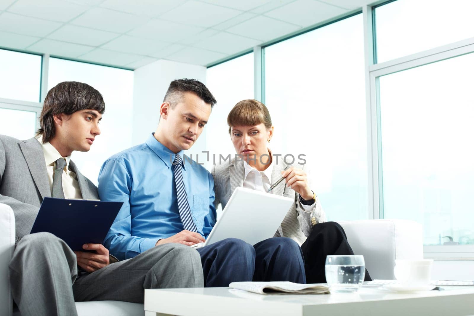 A business team of three sitting in office and planning work