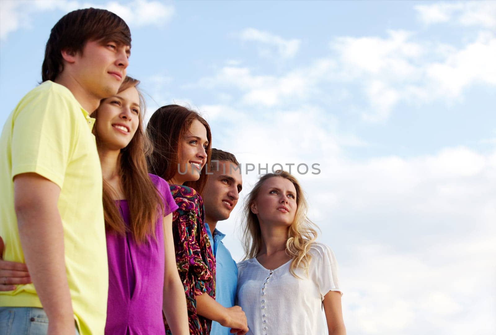 Portrait of happy girls and guys looking forward outdoors