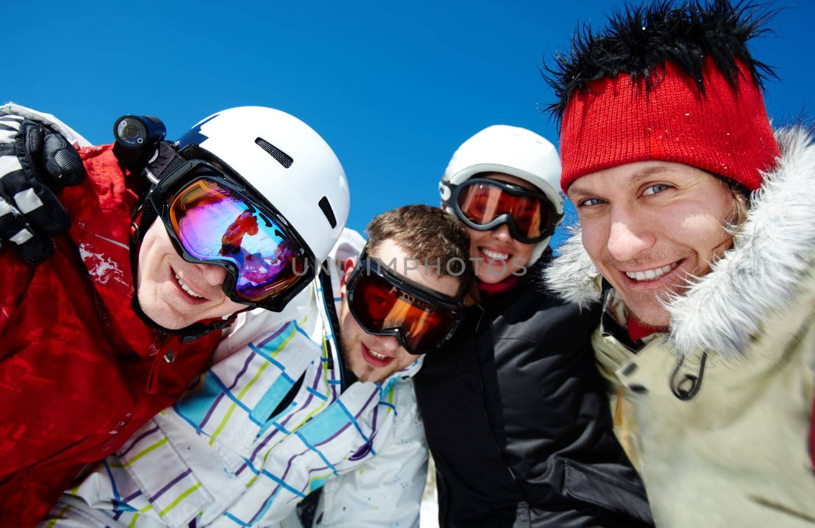Portrait of happy company of guys and girl in googles looking at camera
