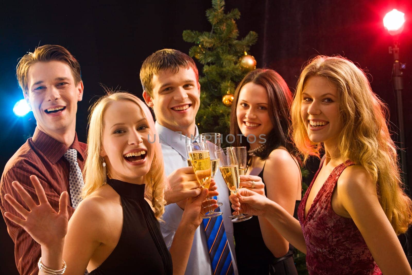 Smiling group of young people enjoying cocktails at christmas