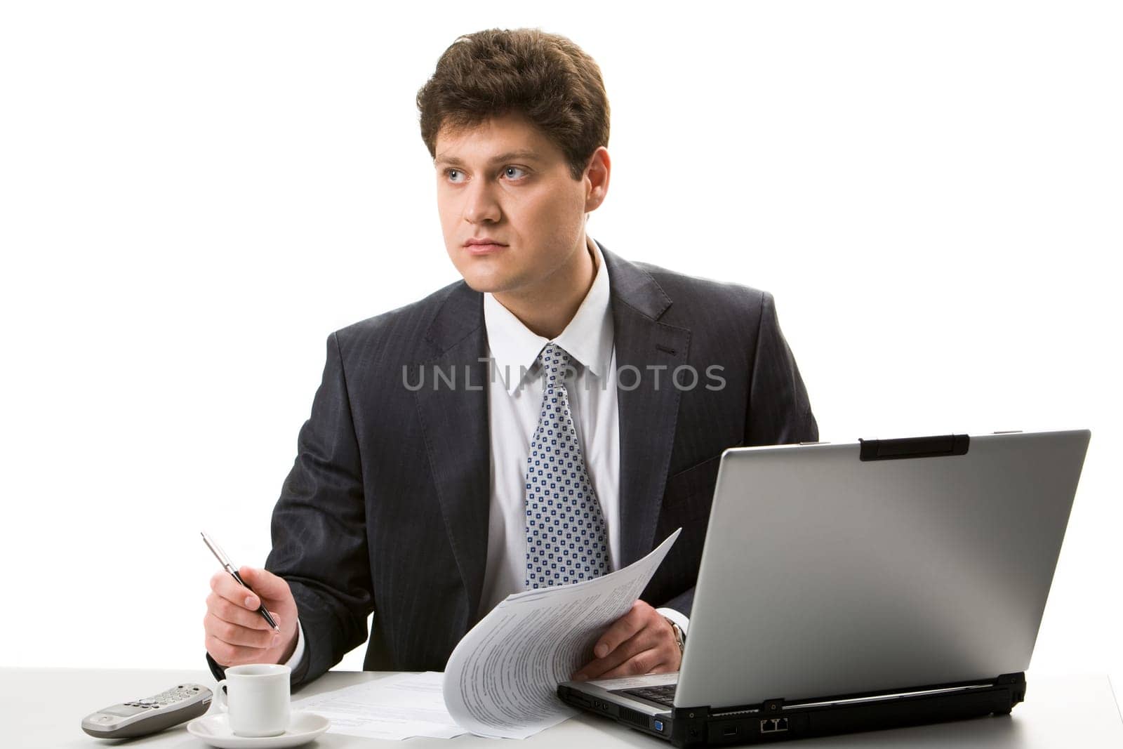 Portrait of confident businessman sitting at workplace and looking aside