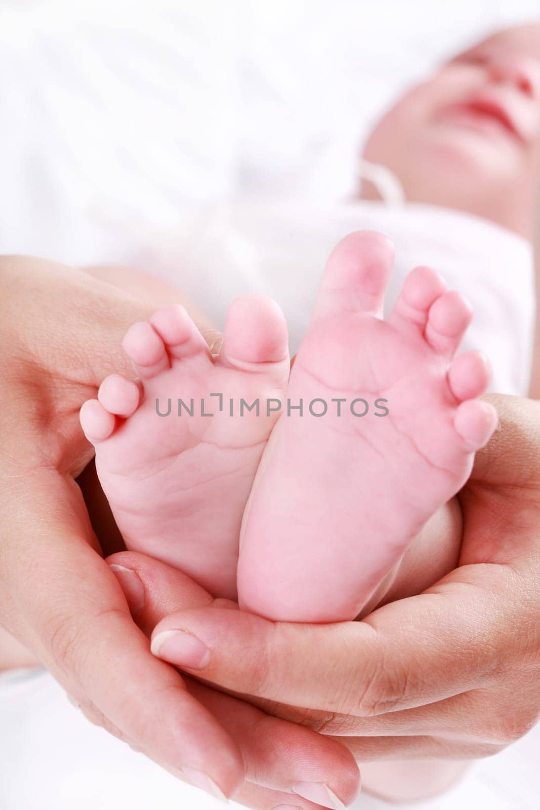 Detail of newborn&#039 s feet in mother&#039 s hands - shallow DOF