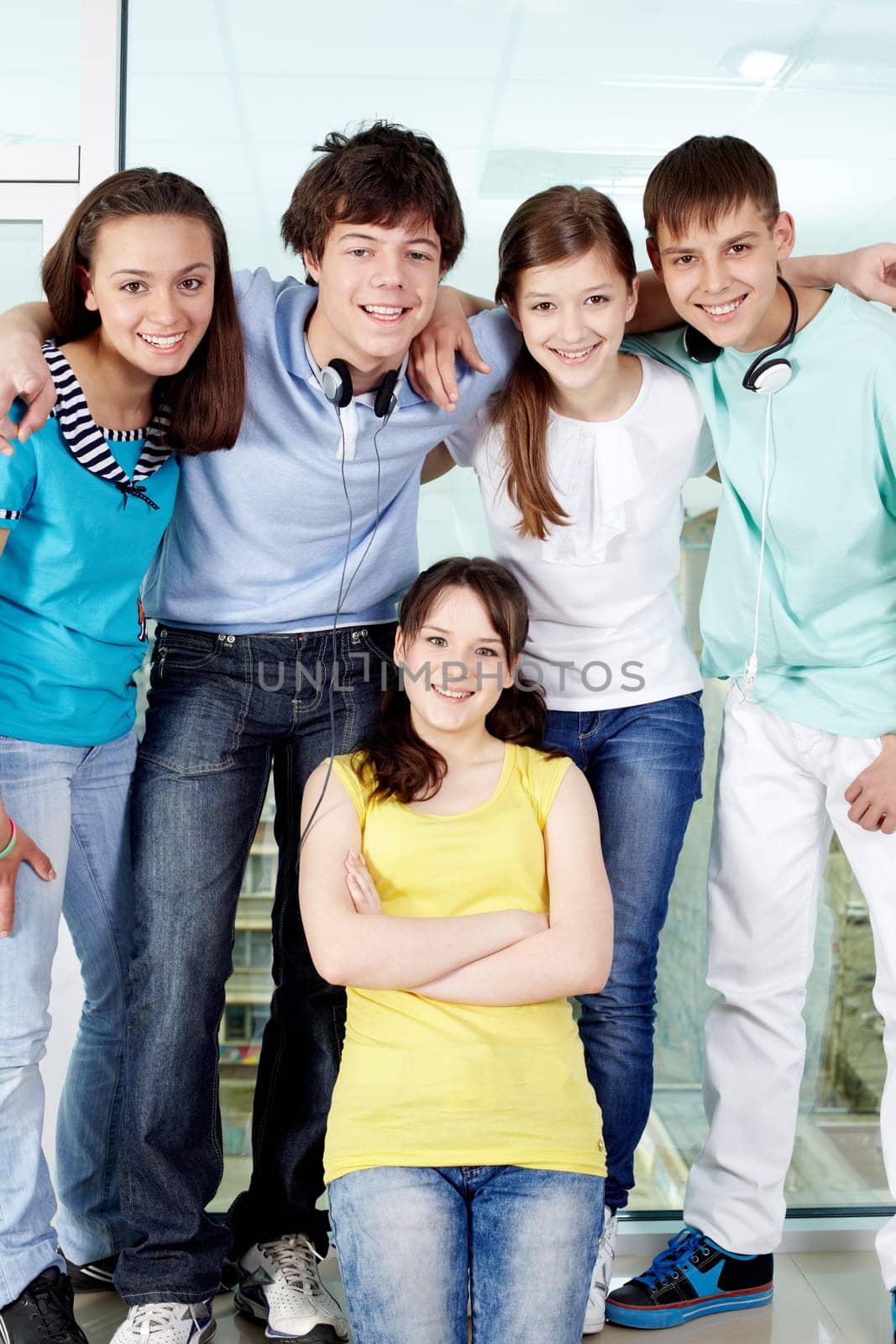 Four friends standing on window-sill with one girl below and smiling