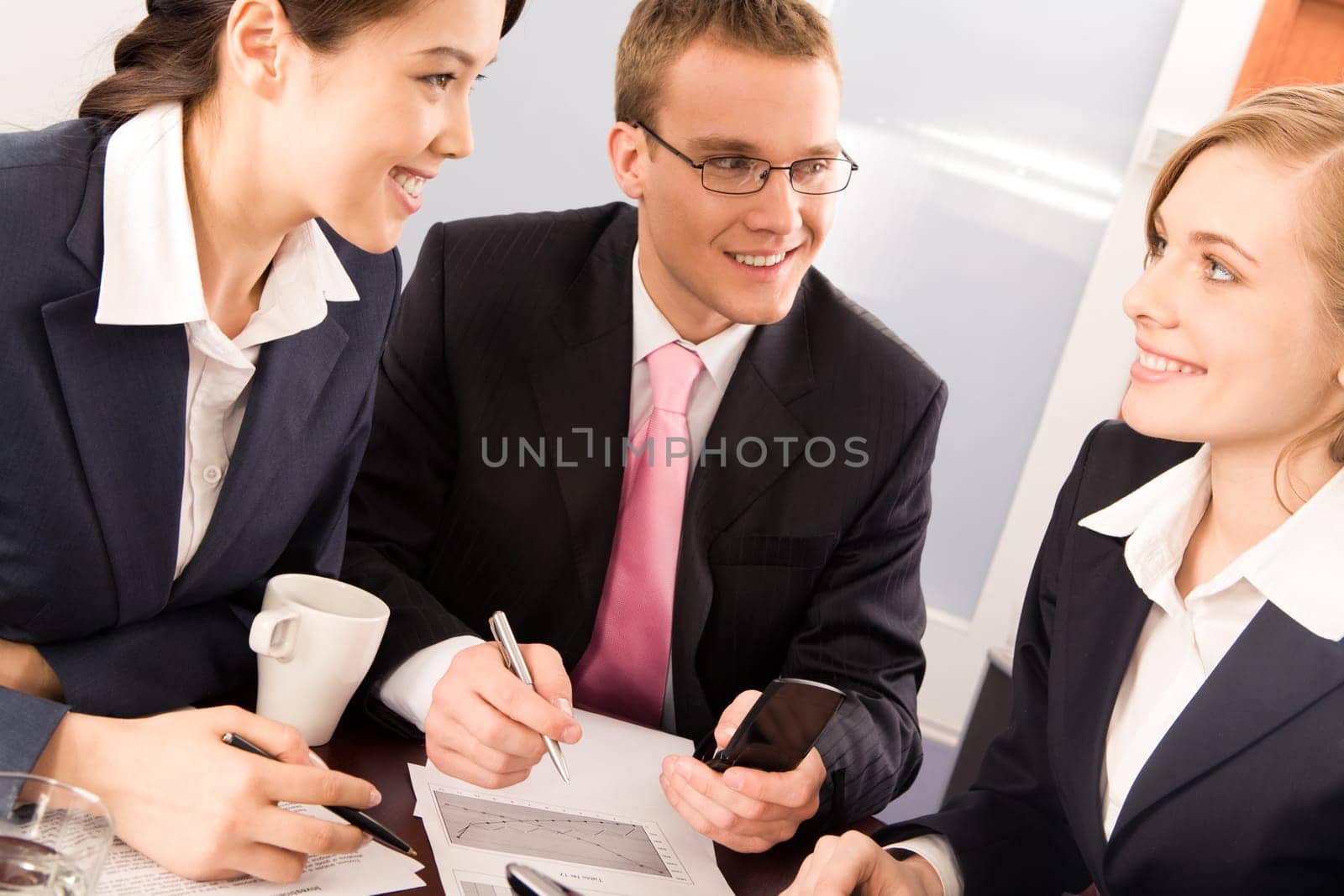 Photo of two confident business people looking at smiling woman in office