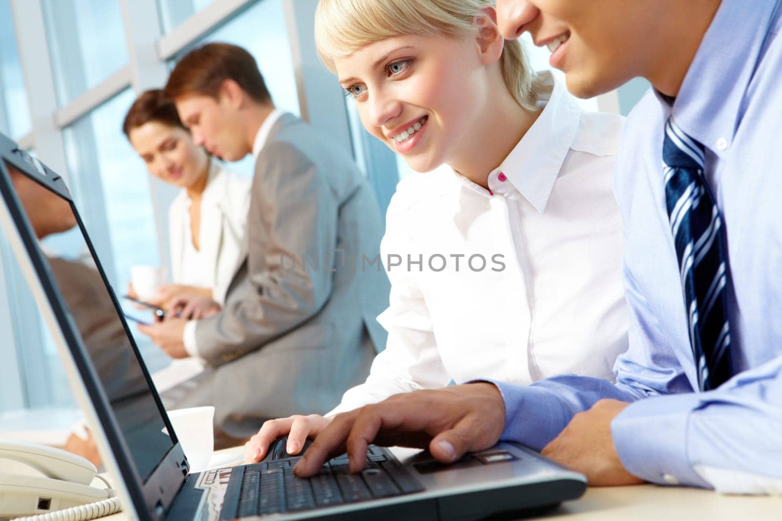 Portrait of executive partners looking at laptop display while working in office