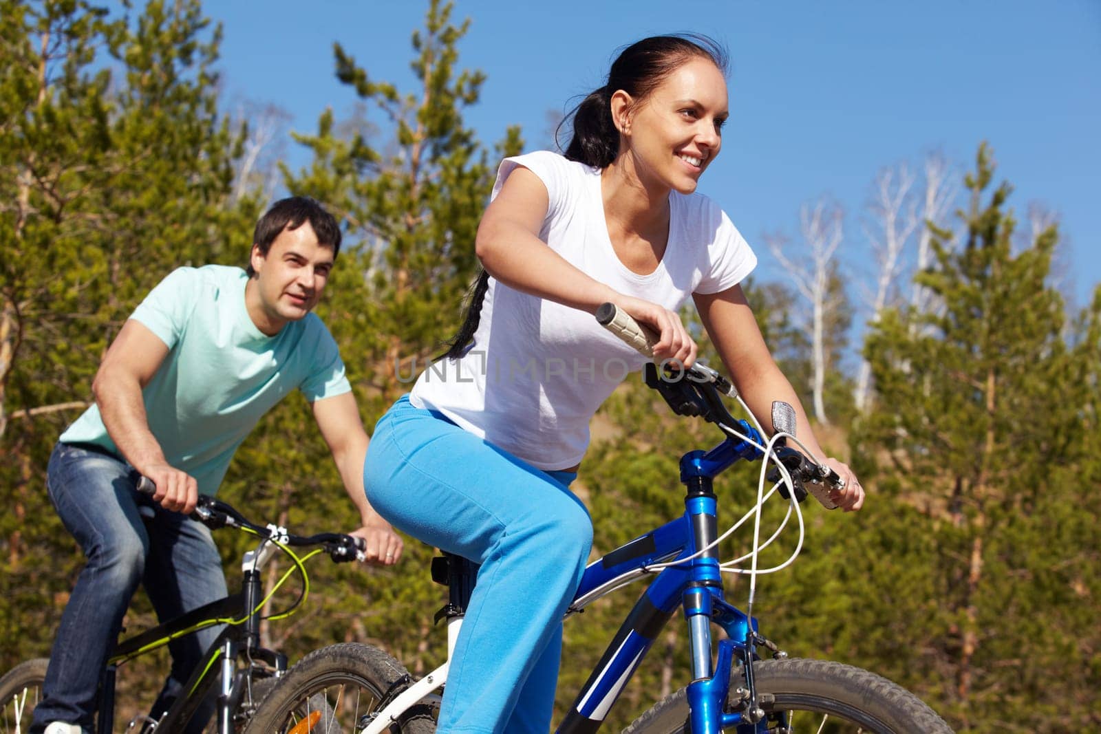 A young couple racing on bicycles