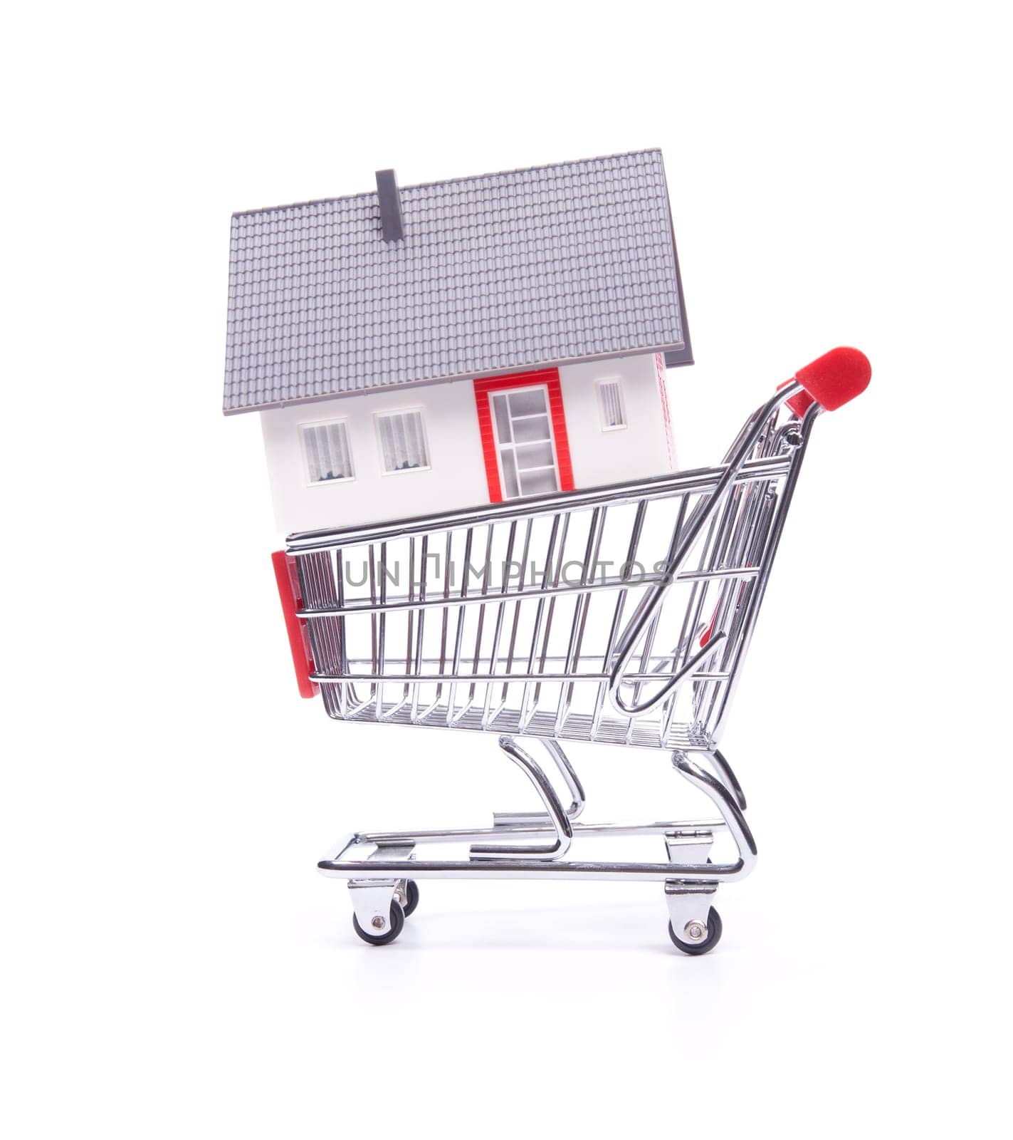 Buy new house concept - model of the house in shopping cart on white background.