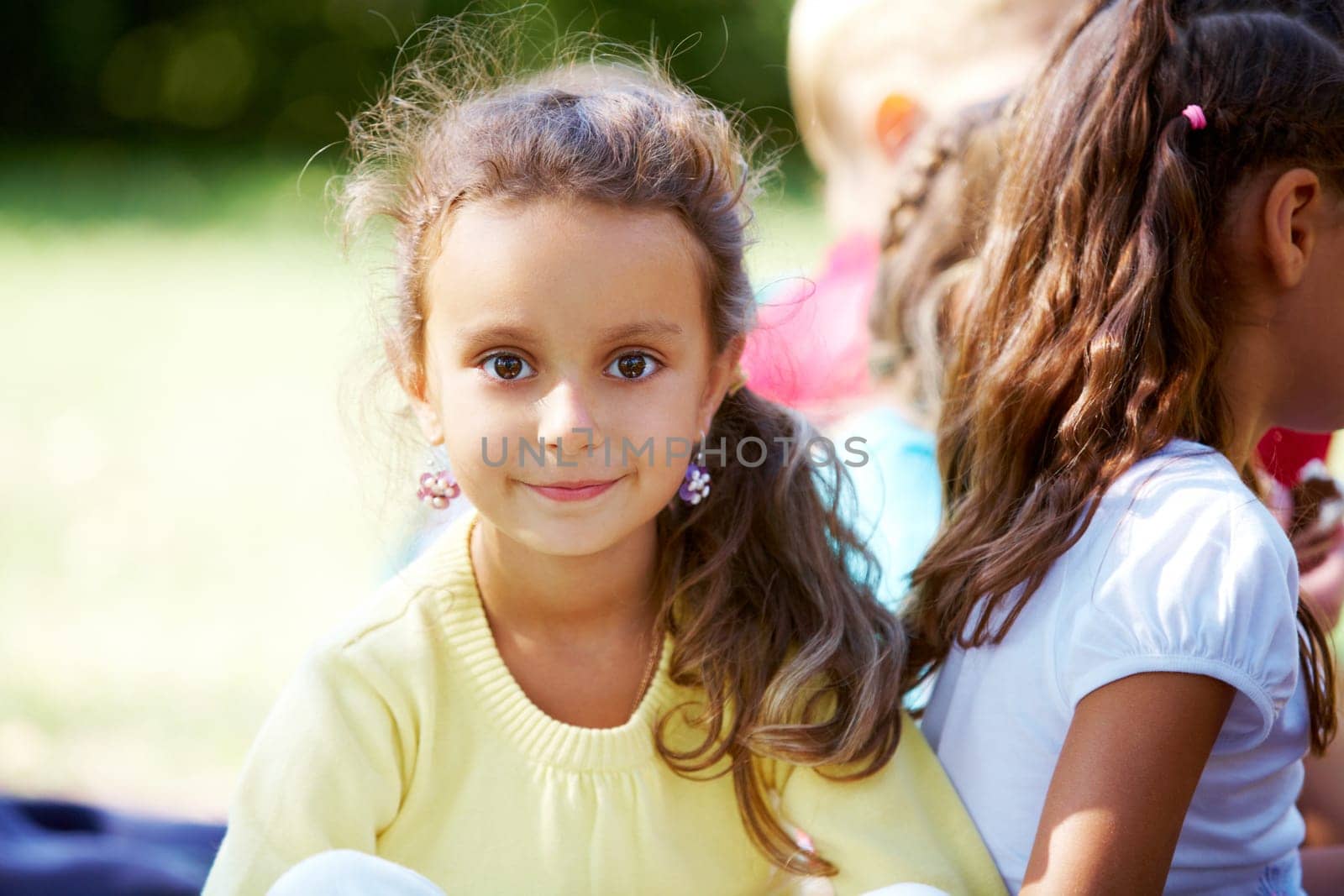 Portrait of happy girl looking at camera with her friends near by