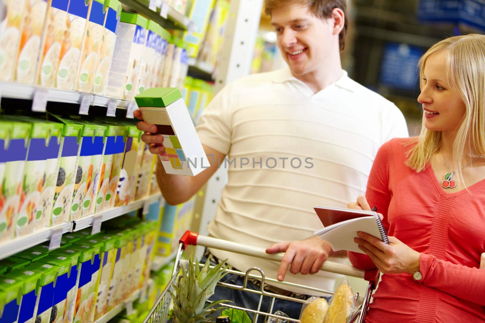 Image of happy couple choosing goods in supermarket