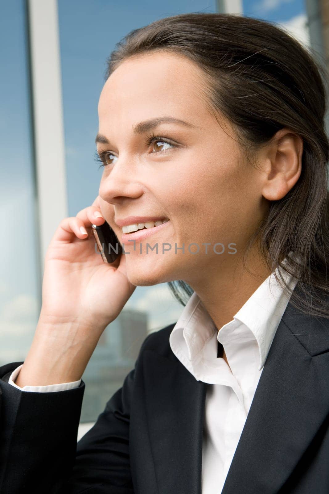Profile of successful businesswomans face with her hand holding cellular phone