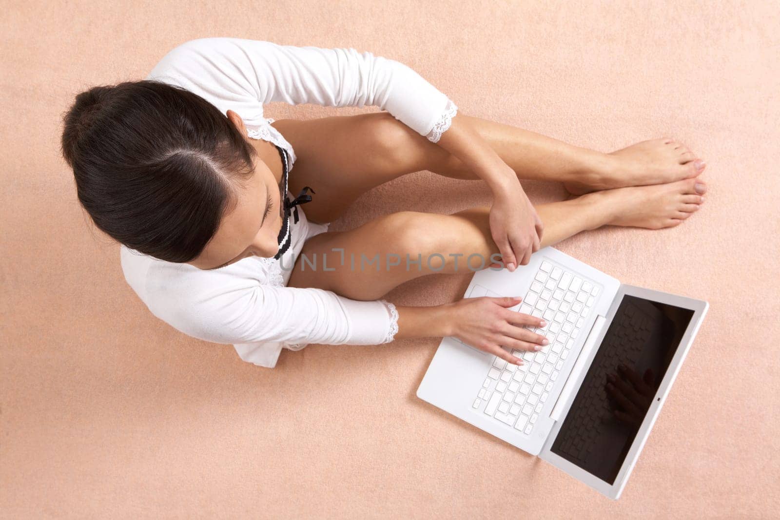 View from above of girl sitting and typing on laptop