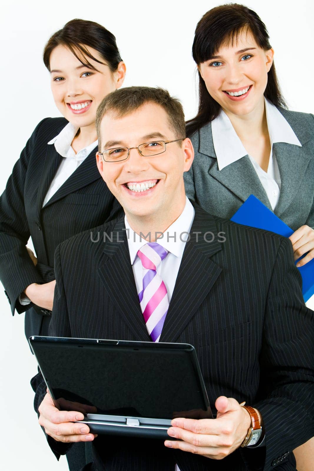 Portrait of three confident business partners looking at camera with smiles with leader holding laptop in front