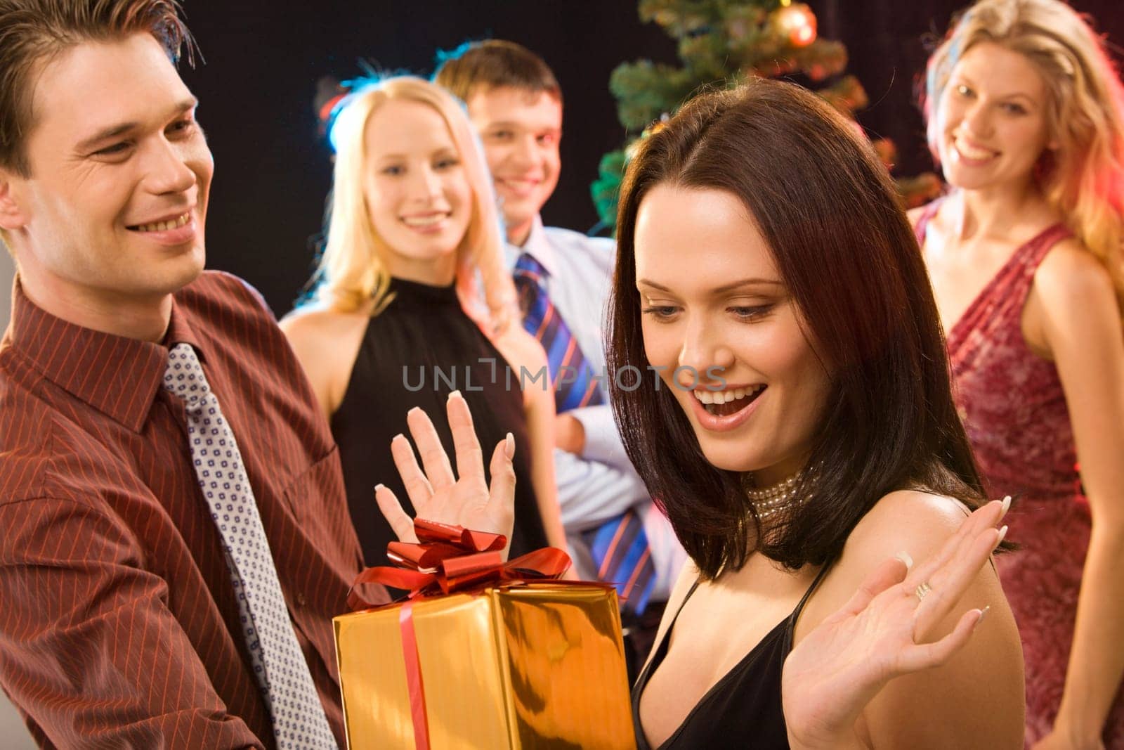 Photo of man giving to pretty woman the present at christmas
