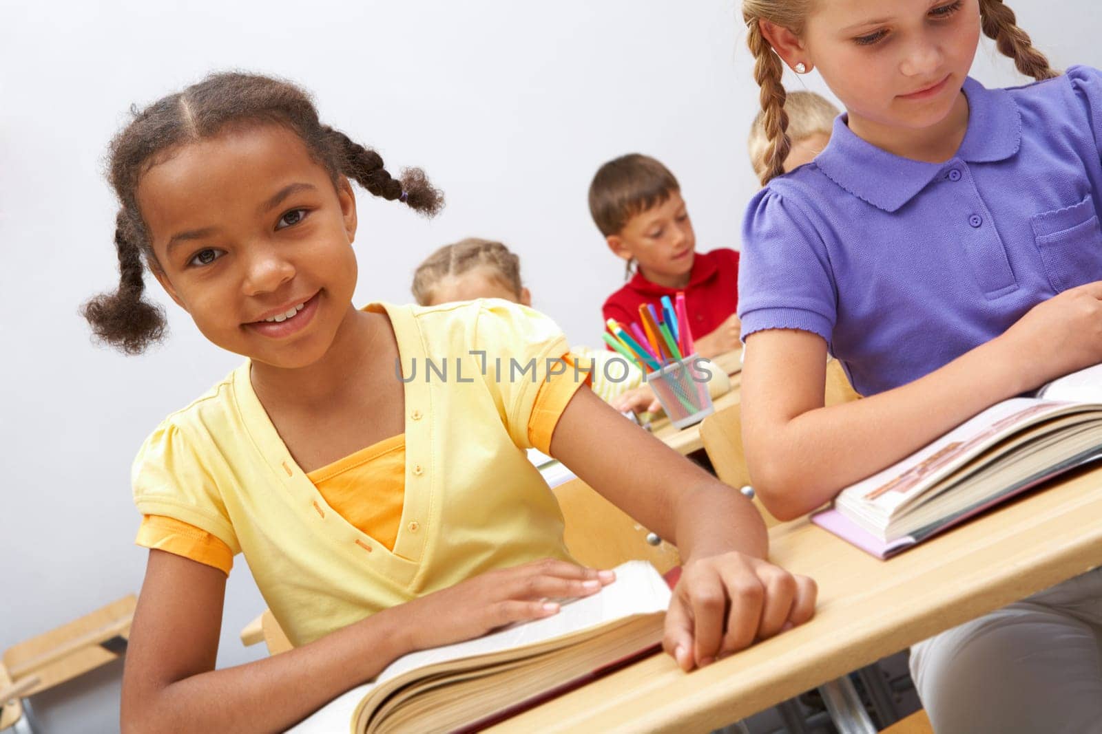 Portrait of smart pupils sitting in the classroom and reading