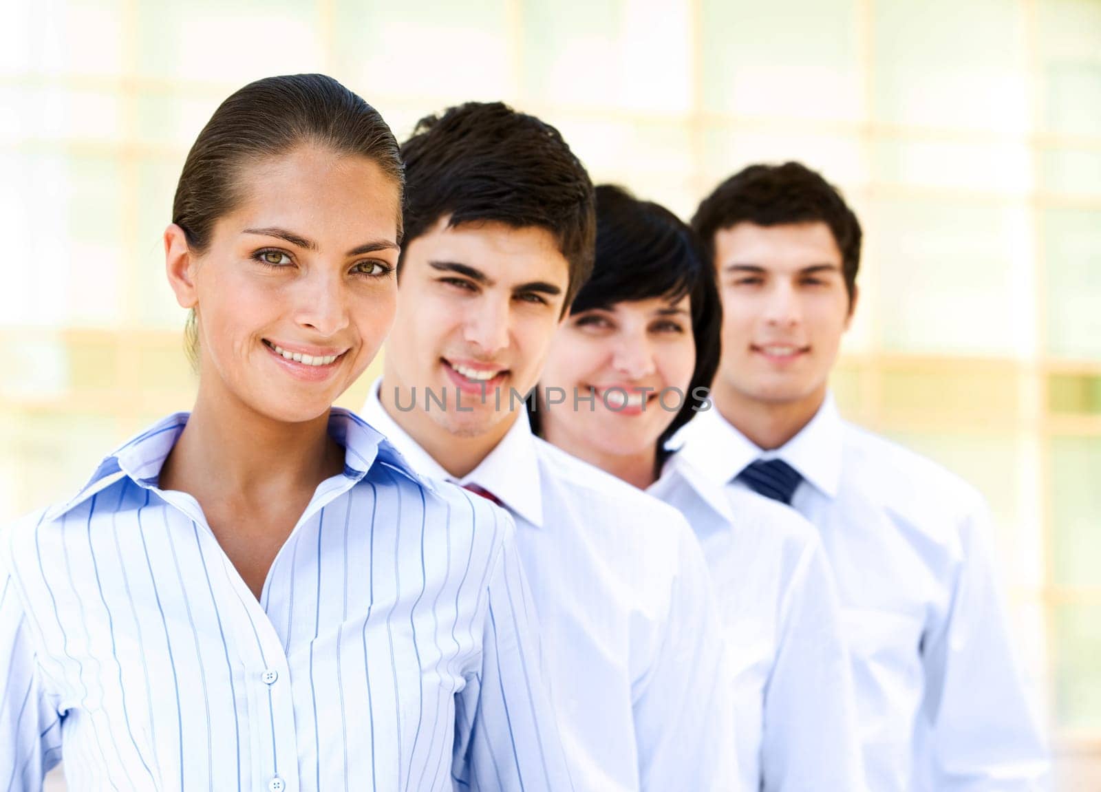 Portrait of attractive leader of friendly business group standing in line behind
