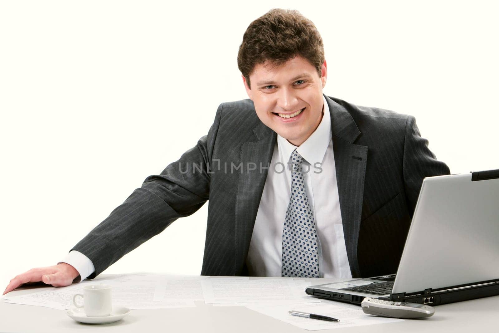 Portrait of confident businessman sitting at workplace and looking at camera